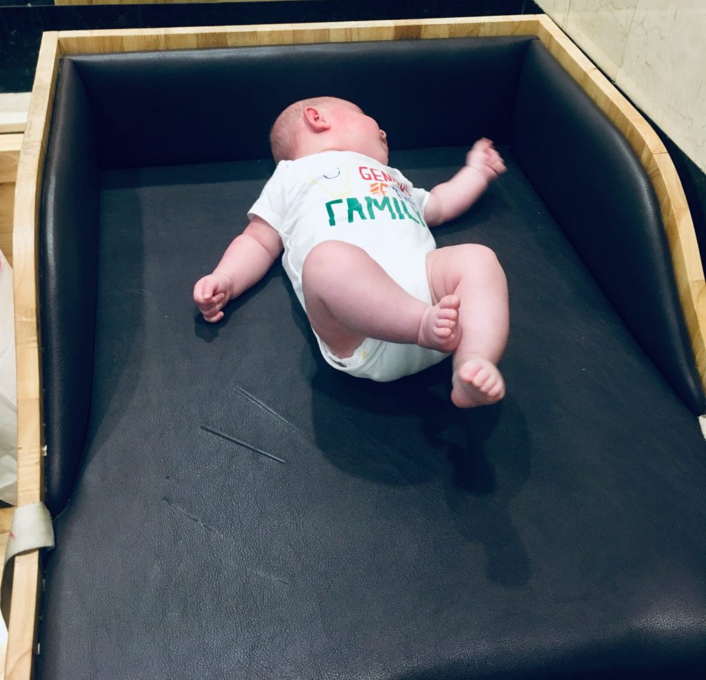 A newborn baby laid on a baby change mat in the changing room of a mall in Ho Chi Minh City, vietnam
