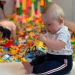 A 6 month old baby sat upright playing with LEGO at Lego House in Billund, Denmark