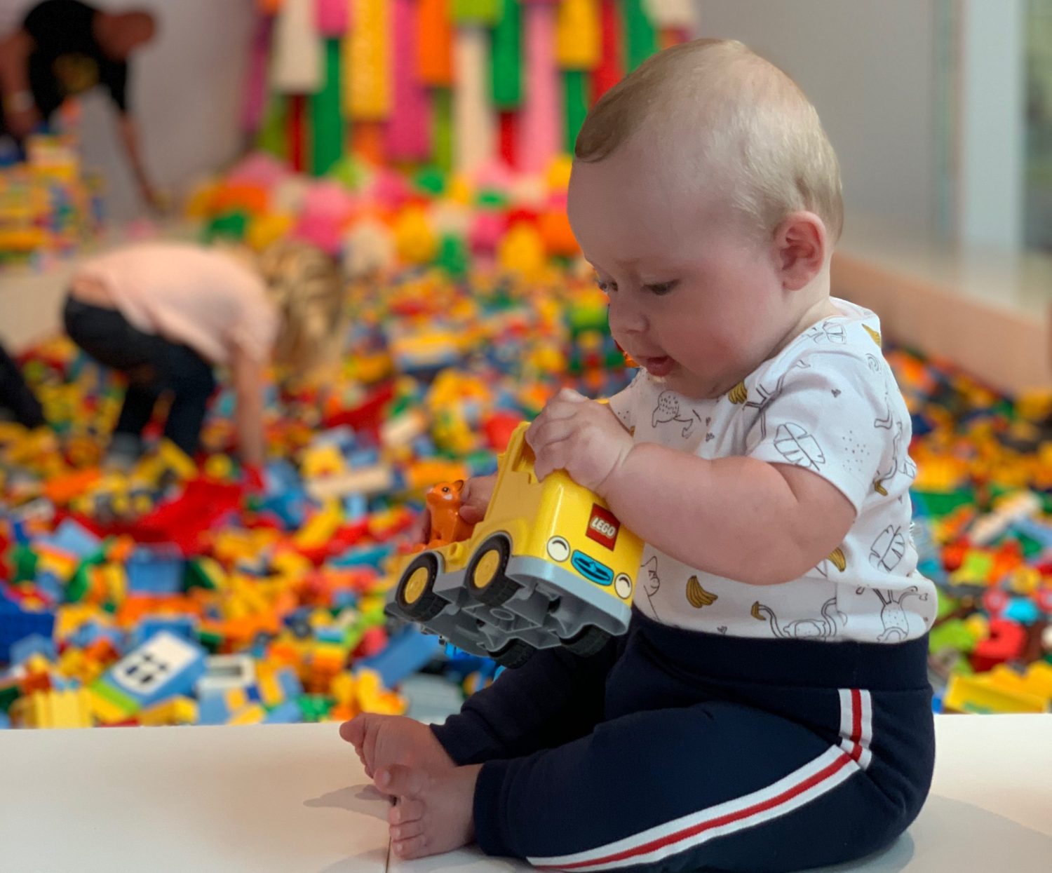 A 6 month old baby sat upright playing with LEGO at Lego House in Billund, Denmark